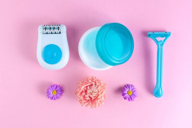 Epilatör, krem, kadınlar jilet ve çiçekler pembe bir arka plan üzerinde tıraş. Depilatory. İstenmeyen saç kaldırılması. Spa ve erkek tedavileri. Epilasyon kavramı