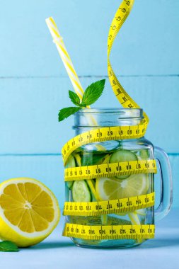 Diyet kavramı. Detoks içecekler. Limon suyu, sulu limon, nane ve mavi bir arka plan üzerinde ölçüm bandı. Detoks 