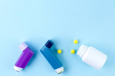 Astım inhaler ve hap mavi bir arka plan üzerinde. Kopya alanı 