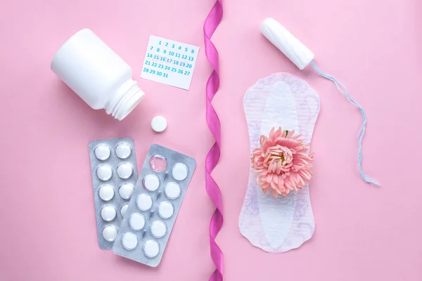 Tampon, feminine, sanitary pads for critical days, female calendar, pain pills during menstruation and a pink flower on a pink background. Care of hygiene during menstruation. Regular menstrual cycle. Monthly protection