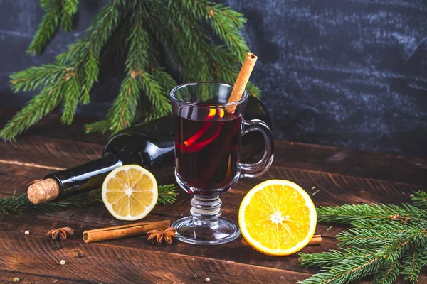 Christmas mulled wine in a glass with citrus fruits and spices. Christmas and New Year holidays. Cozy, warm, winter evenings. Winter drinks