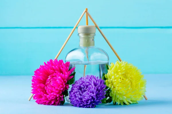 Air freshener and flowers on a blue background. Diffuser, fresh air. Aroma therapy