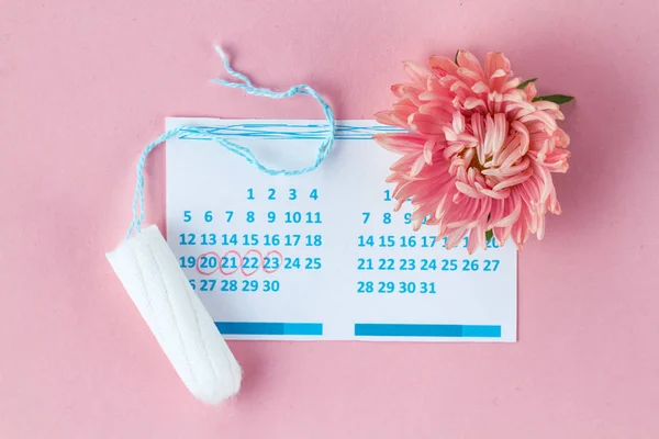 女性のカレンダーとピンクの背景の上に花のタンポン 重要な日の間に衛生ケア 定期的な月経周期 — ストック写真