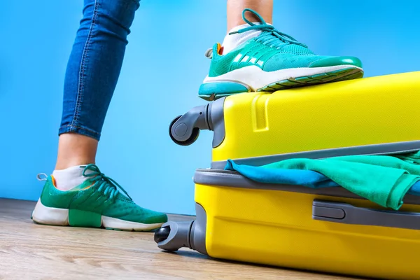 Packing clothes in a yellow suitcase. Pack necessary items for travel or business trip. Vacation, holiday. Travel concept