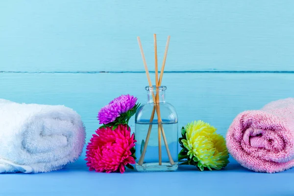 Spa. Air diffuser, towels and flowers on a blue background. Aromatherapy, relaxation. Spa treatments