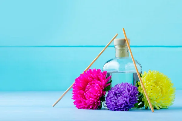 Air freshener and flowers on a blue background. Diffuser, fresh air. Aroma therapy