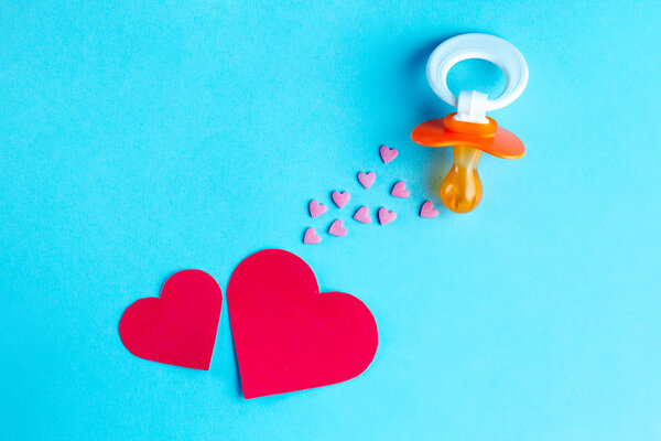 Nipple and hearts on a blue background. Planning the birth of a child. Future motherhood. Waiting for the baby. Planning to become a parent. Pregnancy concept. 