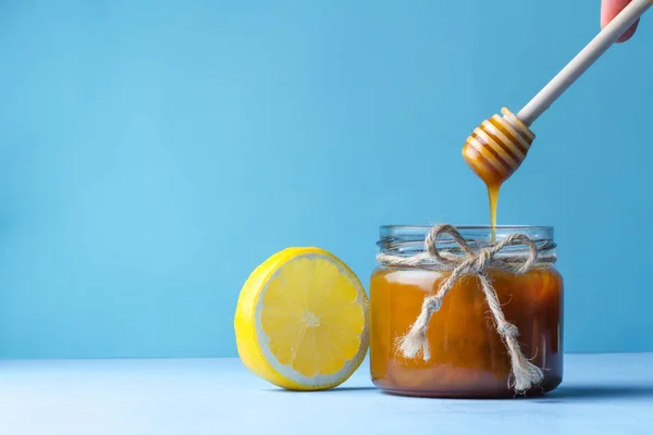 Tarro Miel Jugosa Cuchara Limón Miel Sobre Fondo Azul — Foto de Stock