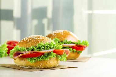 Taze marul, domates, jambon için meze ile iştah açıcı susam buns. Ev yapımı sandviçler