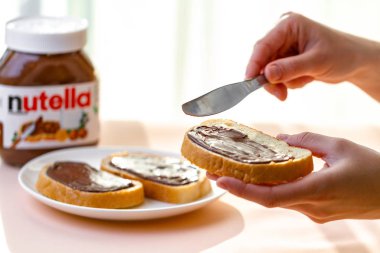 Batum, Gürcistan - 24 Kasım, 2018. Uzun bir somun üzerinde Nutella adet yayıldı. Fındık, çikolata, tatlı sandviçle yapıştırın ve bir kahvaltıda süt. Nutella kahvaltı 