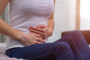 Genç kadın kendini kötü hissediyor ve Pms ve Hayız döneminde karın ağrısı deneyimi. Ağrılı adet. İnflamasyon ve mesane enfeksiyonu