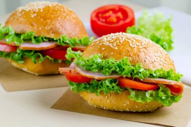 Taze marul, domates, jambon için meze ile iştah açıcı susam buns. Ev yapımı sandviçler