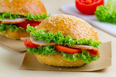 Taze marul, domates, jambon için meze ile iştah açıcı susam buns. Ev yapımı sandviçler