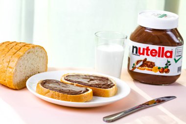 Batum, Gürcistan - 24 Kasım, 2018. Nutella taze pişmiş ekmek üzerinde yayılmış. Fındık, çikolata, tatlı sandviçle yapıştırın ve bir kahvaltıda süt. Nutella kahvaltı 