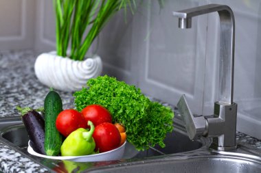 Kadın evde mutfakta sebze yıkama. Taze sebze salatası için. Sağlıklı gıda kavramı. Sağ Gıda, doğru beslenme. Ev yapımı yiyecek konsepti.