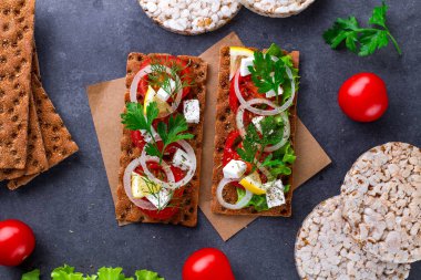 Peynir, domates, marul, soğan, taze maydanoz ve dereotu ile net sandviç. Aperatif ekmek ve fitness yeme. Gevrek ekmek çavdar ve buğday ve pirinç ekmek