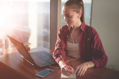 Online eğitim hizmetini kullanarak öğrenci. Eğitim yabancı dil kursları ve kulaklık ile dinleme izlerken laptop ekranında arayan genç kadın. Modern çalışma teknoloji kavramı. 