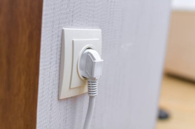 Beyaz güç kablosu kablosu duvardaki prize takılı