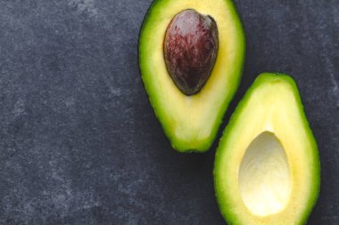 Tropikal meyve karanlık bir arka plan üzerinde avokado. Kopya alanı, üstten görünüm 