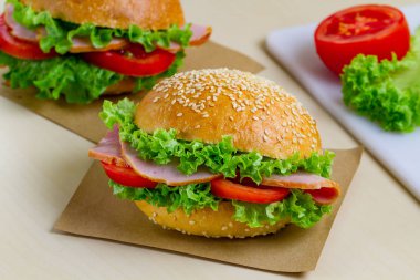 Taze marul, domates, jambon için meze ile iştah açıcı susam buns. Ev yapımı sandviçler
