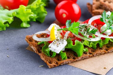 Peynir, domates, marul, soğan, taze maydanoz ve dereotu ile net sandviç. Aperatif ekmek ve fitness yeme. Gevrek ekmek çavdar ve buğday ve pirinç ekmek