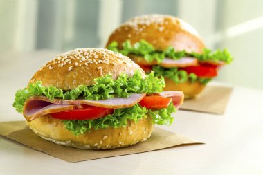 Taze marul, domates, jambon için meze ile iştah açıcı susam buns. Ev yapımı sandviçler