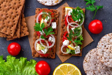 Peynir, domates, marul, soğan, taze maydanoz ve dereotu ile net sandviç. Aperatif ekmek ve fitness yeme. Çavdar ve buğday gevrek ekmek ve pirinç ekmek. Düz yatıyordu, en iyi görünümü 