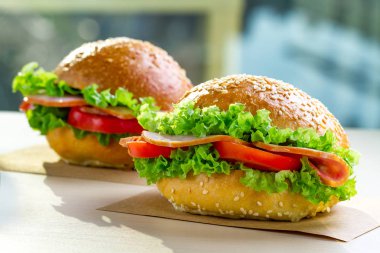 Taze marul, domates, jambon için meze ile iştah açıcı susam buns. Ev yapımı sandviçler