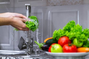 Kadın mutfakta sebze yıkama. Sebze salatası yemek pişirmek için. Doğru ve sağlıklı gıda, doğru beslenme. 