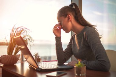 Göz yorgunluğu, bilgisayar çevrimiçi uzun işten sonra. Freelancer iş uzun bir günün ardından göz yorgunluğunu hissediyor ve bir dizüstü bilgisayar kullanarak. Fazla çalışma kavramı ve bulanık görme