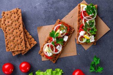 Peynir, domates, marul, soğan, taze maydanoz ve dereotu ile net sandviç. Aperatif ekmek ve fitness yeme. Gevrek ekmek çavdar ve buğday ve pirinç ekmek