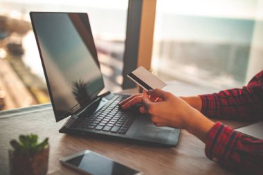Satın alınan ürünler ile bir dizüstü bilgisayar kullanarak kredi kartıyla online alışveriş ve online ödeme. Sipariş ürünler online