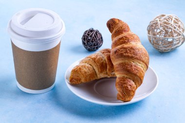 Fransız kahvaltı taze pişmiş kruvasanlar ve bir fincan sıcak kahve ile. Üstten görünüm