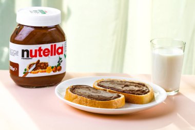 Batum, Gürcistan - 24 Kasım, 2018. Uzun bir somun üzerinde Nutella adet yayıldı. Fındıklı çikolata kremalı sandviç ve süt bir kahvaltı için. Nutella kahvaltı 