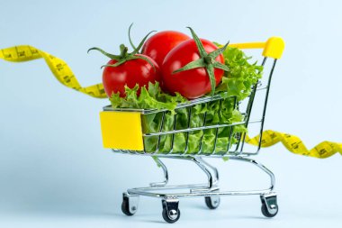 Diyet kavramı. Bir alışveriş sepeti ve sarı bant ölçme taze sebze. Sağlıklı gıda ve doğru beslenme. Doğru bir konsepti yemek 