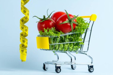 Diyet kavramı. Bir alışveriş sepeti ve sarı bant ölçme taze sebze. Sağlıklı gıda ve doğru beslenme. Doğru bir konsepti yemek 