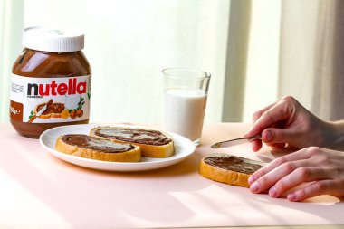 Batum, Gürcistan - 24 Kasım, 2018. Uzun bir somun üzerinde Nutella adet yayıldı. Fındık, çikolata, tatlı sandviçle yapıştırın ve bir kahvaltıda süt. Nutella kahvaltı 