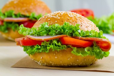 Taze marul, domates, jambon için meze ile iştah açıcı susam buns. Ev yapımı sandviçler