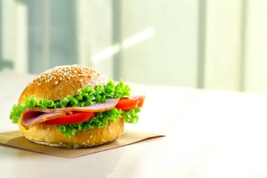 Taze marul, domates, jambon için meze ile iştah açıcı susam çörek. Ev yapımı sandviçler. Kopya alanı 