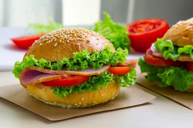 Taze marul, domates, jambon için meze ile iştah açıcı susam buns. Ev yapımı sandviçler
