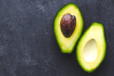 Tropikal meyve karanlık bir arka plan üzerinde avokado. Kopya alanı, üstten görünüm 