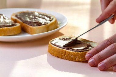 Taze pişmiş ekmek üzerinde çikolatalı hamur yayılır. Chocoalte sandviç Fıstıklı tatlı bir kahvaltı için yapıştırın. 