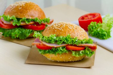 Taze marul, domates, jambon için meze ile iştah açıcı susam buns. Ev yapımı sandviçler