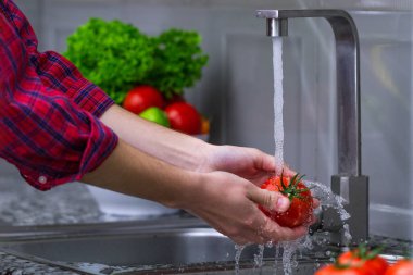 Kadın evde mutfakta sebze yıkama. Taze sebze salatası için. Sağlıklı gıda kavramı. Sağ Gıda, doğru beslenme. Ev yapımı yiyecek konsepti.