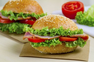 Taze marul, domates, jambon için meze ile iştah açıcı susam buns. Ev yapımı sandviçler