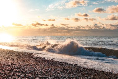 Gün batımında dalgalar ile deniz kıyısı. Gün batımı manzarası. Doğa duvar kağıdı ve arka plan 