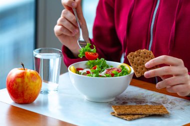 Genç kadın net çavdar ekmeği ile sağlıklı, taze, sebze Salata yiyor. Diyet ve sağlıklı yaşam konsepti. Diyet yemekleri. Doğru beslenme ve doğru yemek 