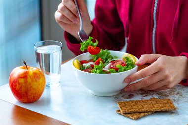 Genç kadın net çavdar ekmeği ile sağlıklı, taze, sebze Salata yiyor. Diyet ve sağlıklı yaşam konsepti. Diyet yemekleri. Doğru beslenme ve doğru yemek 