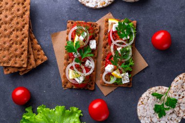 Peynir, domates, marul, soğan, taze maydanoz ve dereotu ile net sandviç. Aperatif ekmek ve fitness yeme. Gevrek ekmek çavdar ve buğday ve pirinç ekmek