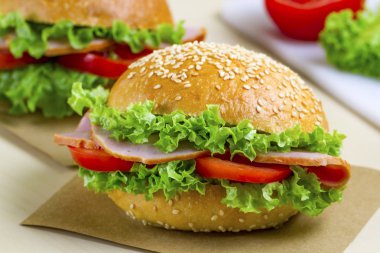 Taze marul, domates, jambon için meze ile iştah açıcı susam buns. Ev yapımı sandviçler